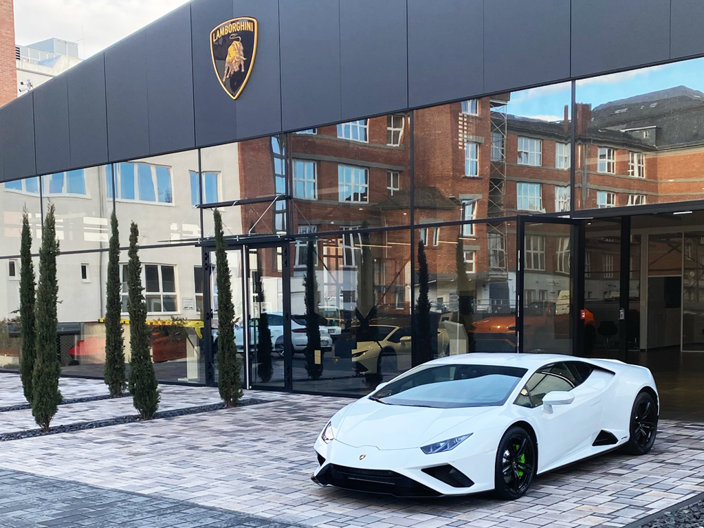 weißer Lamborghini vor einem Autohaus
