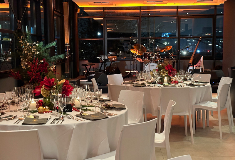 Gedeckter Banketttisch bei einem weihnachtlichen Firmenevent und im Hintergrund Musikinstrumente einer Band