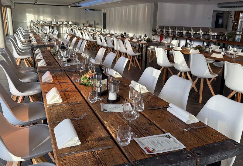 Rustikale Holz-Tische mit minimalistischer Dekoration bei einer Weihnachtsfeier