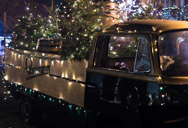 Altes Fahrzeug bei einer Outdoor-Weihnachtsfeier, geschmückt mit Lichterketten