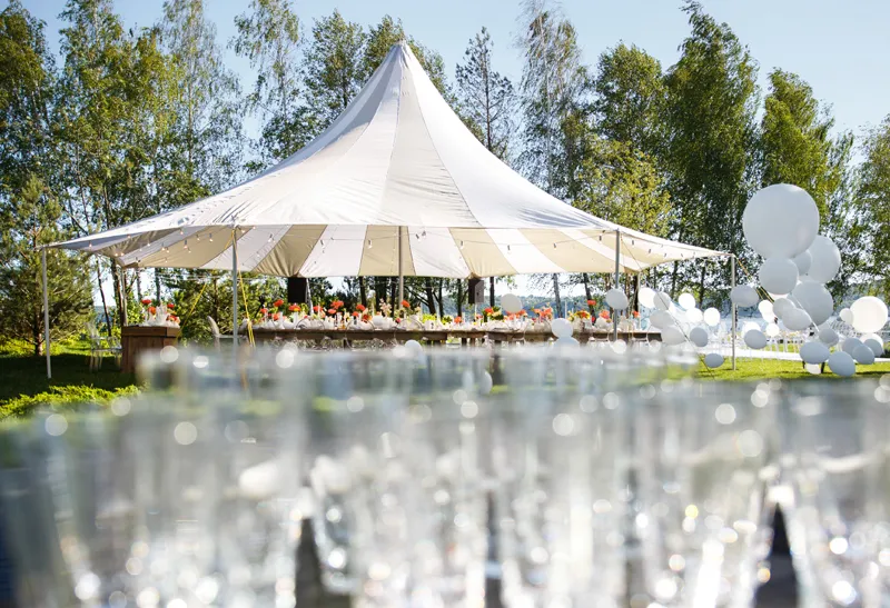 Empfangssituation bei einer Outdoor Veranstaltung mit großem Zelt und Sektgläsern