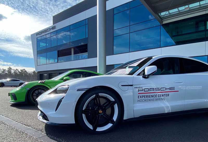 Zwei Porsche Fahrzeuge vor dem Porsche Experience Center am Hockenheimring