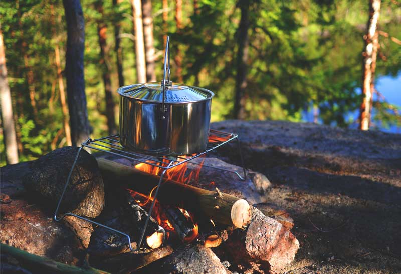 Kochstelle auf offenem Feuer direkt im Wald mit Camping